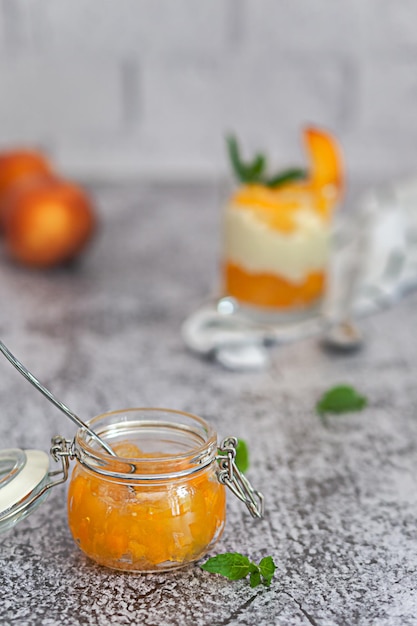 Pot de confiture de pêches sur fond de mur de briques blanches