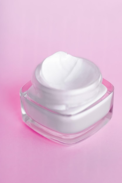 Pot de crème hydratante pour le visage sur fond rose lotion de soin hydratante pour la peau et émulsion de levage cosmétiques anti-âge pour la marque de soins de beauté de luxe