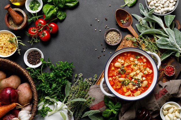 Un pot de cuisine italienne sur une table avec un bol de pâtes et de légumes.