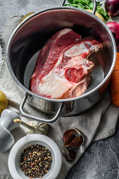 Pot avec du veau sur l'os. Ingrédients pour soupe, légumes et épices. Vue de dessus