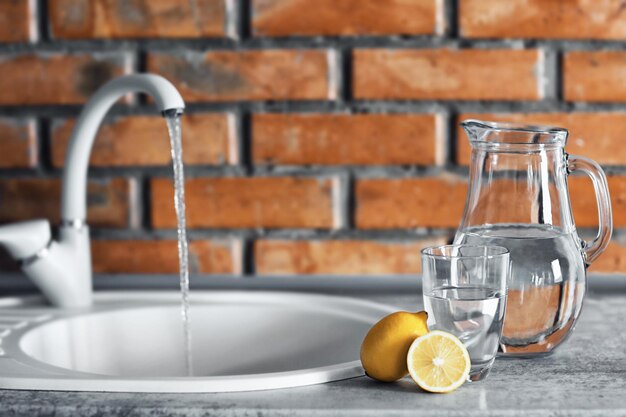 Photo pot avec de l'eau et du citron sur la table de cuisine