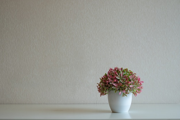 Pot de fleurs sur le bureau sur mur gris