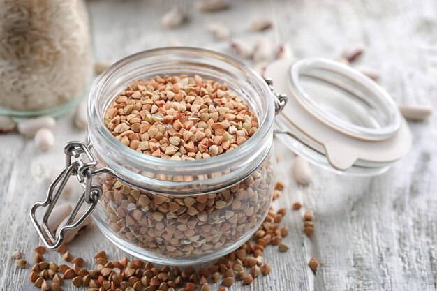 Pot avec des grains de sarrasin sur table en bois