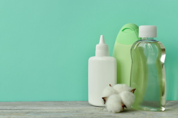 Un pot d'huile, une bouteille de shampoing, de la poudre pour bébé sur l'étagère