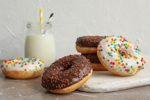 Pot de lait et de délicieux beignets sur table grise