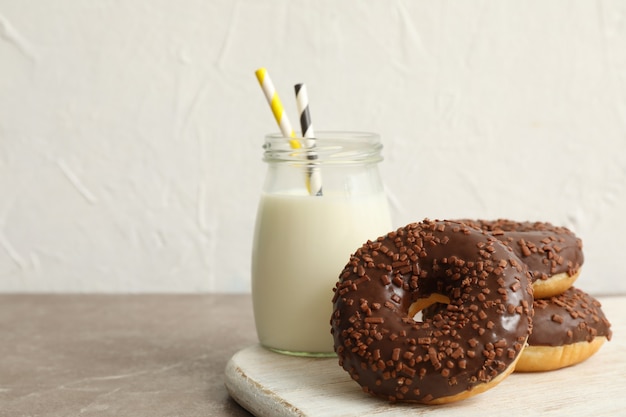 Pot de lait et de délicieux beignets sur table grise