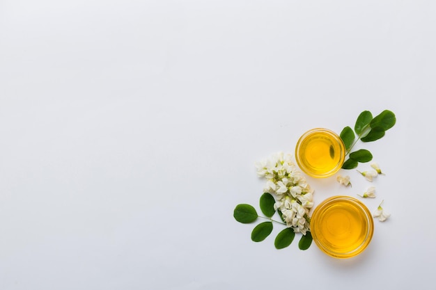 Pot de miel avec des fleurs d'acacia et des feuilles de miel frais vue de dessus à plat