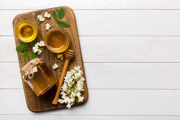 Pot de miel avec des fleurs d'acacia et des feuilles de miel frais vue de dessus à plat