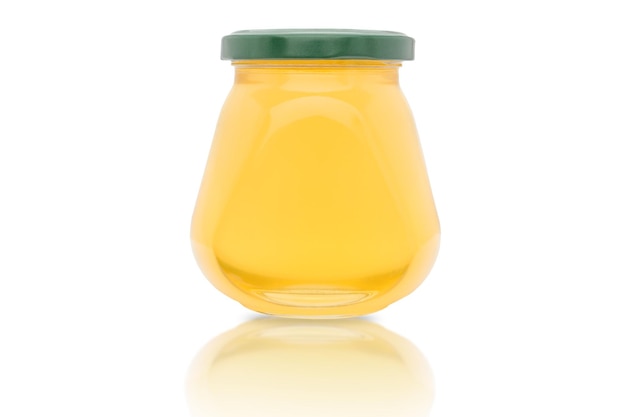 Un pot de miel jaune frais sur fond blanc