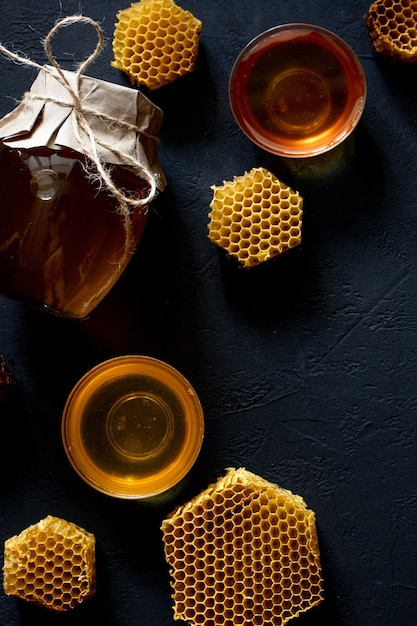 Pot de miel avec nid d'abeille sur table noire