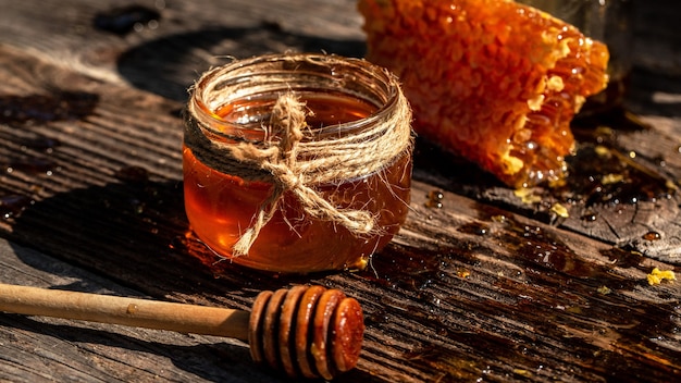 Pot de miel, rayon de miel et bâton de miel sur table en bois