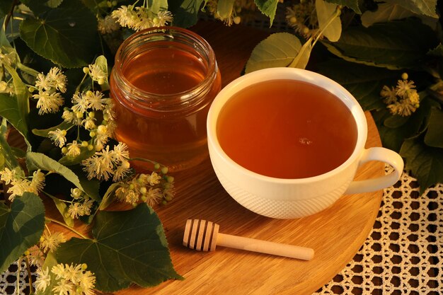 pot de miel de tilleul avec fleur de tilleul et tasse de thé