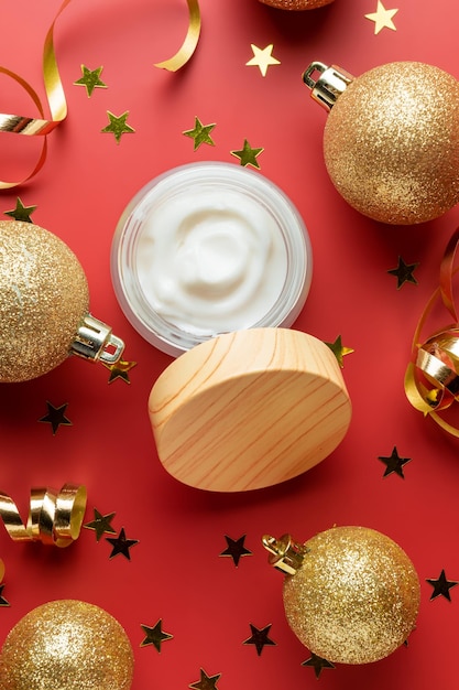 Pot ouvert blanc sans marque avec crème ou masque facial sur fond rouge festif de vacances de nouvel an Présentation de soins de beauté pour les vacances en cadeau