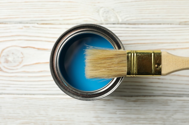 Pot de peinture et pinceau sur table en bois, vue de dessus