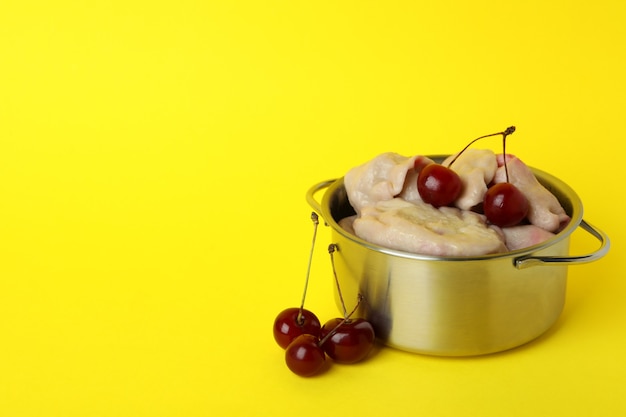 Pot à pierogi avec cerise sur fond jaune