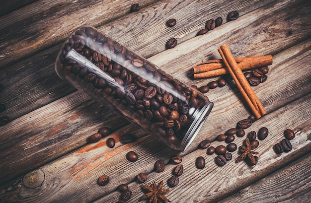 Pot en plastique avec des grains de café sur une table en bois