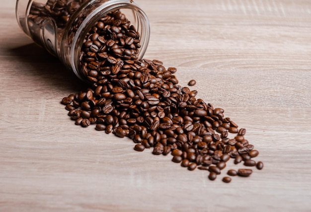 Pot plein de café tombé en renversant des grains de café