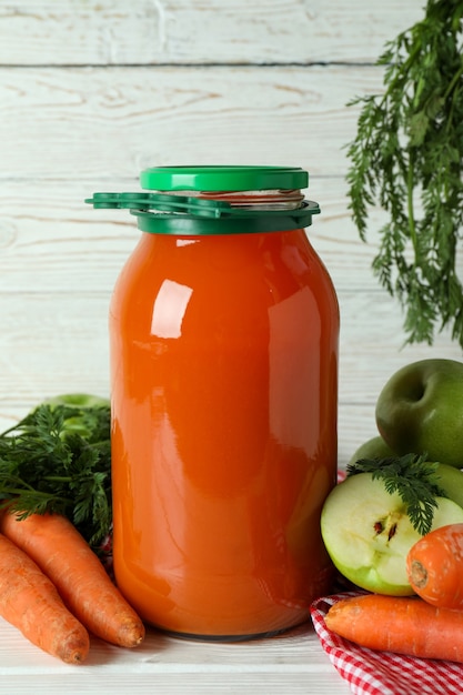 Pot de pomme - jus de carotte et ingrédients sur bois blanc