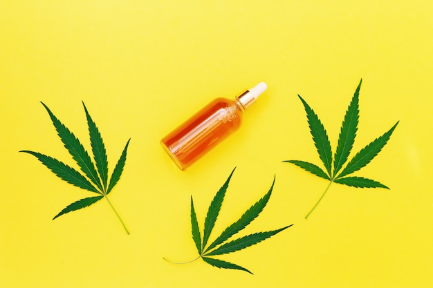 Pot avec produit cosmétique avec de l'huile de cannabis sur jaune