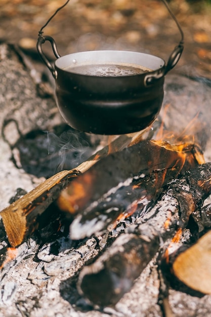 Pot de randonnée melon dans le feu de joie la soupe bout dans le chaudron sur le bûcher voyage tourisme pique-nique cookin