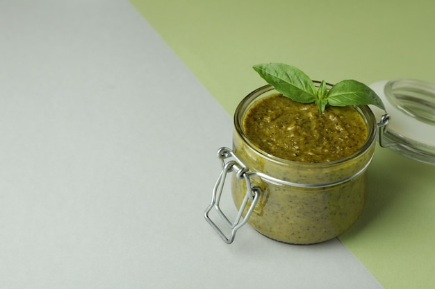 Pot de sauce pesto sur fond bicolore