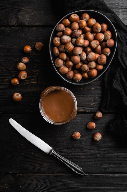 Pot à tartiner au chocolat sur fond de table en bois noir vue de dessus mise à plat