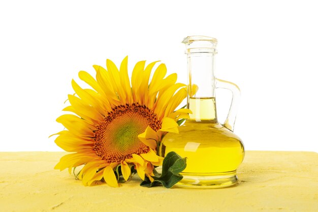 Pot de tournesol et verre d'huile sur table jaune isolé