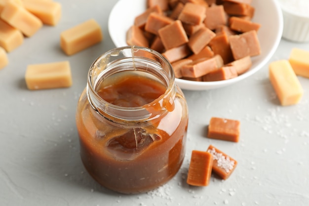 Pot en verre avec caramel salé et bonbons bouchent