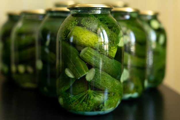 Pot en verre avec concombres marinés sur gris