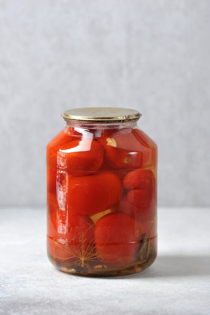 Pot en verre avec couvercle en fer avec tomates rouges en conserve