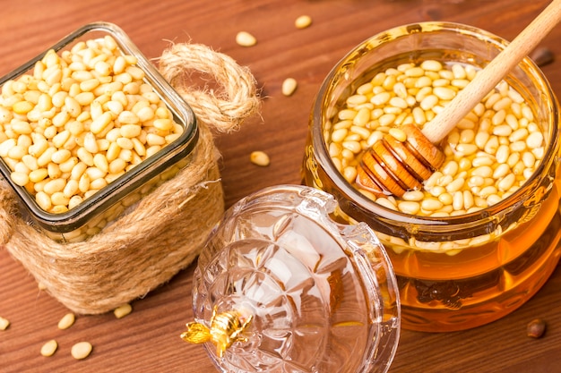 Un pot en verre de délicieux miel avec des pignons de pin