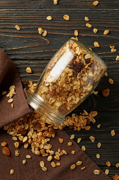 Pot en verre avec du granola savoureux sur fond de bois