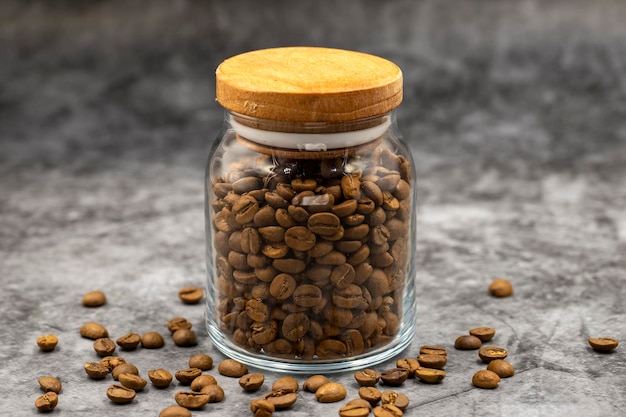 Pot en verre avec des grains de café sur fond sombre Close up of coffee