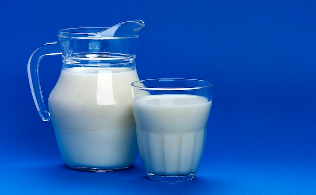 Pot et verre de lait sur bleu