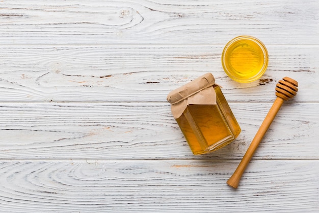 Pot en verre de miel avec bruine en bois sur fond coloré Pot de miel et balancier haut au-dessus de l'espace de copie vue de dessus