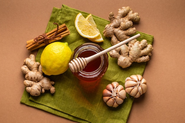 Pot en verre de miel, gingembre, ail, citron, vue de dessus de cannelle pour renforcer le système immunitaire. Ingrédients alimentaires naturels pour la stimulation de l'immunité et la protection contre les virus. Alimentation saine contre la grippe saisonnière et le rhume