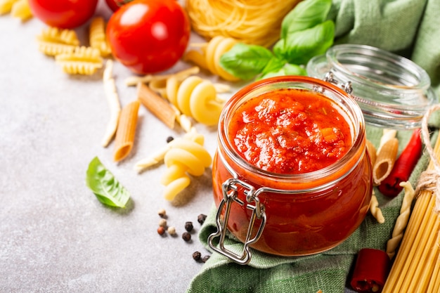 Pot en verre avec des pâtes tomates épicées classiques maison ou une sauce à pizza.