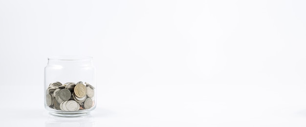 Pot en verre avec des pièces sur un fond blanc Pot d'argent isolé sur fond blanc