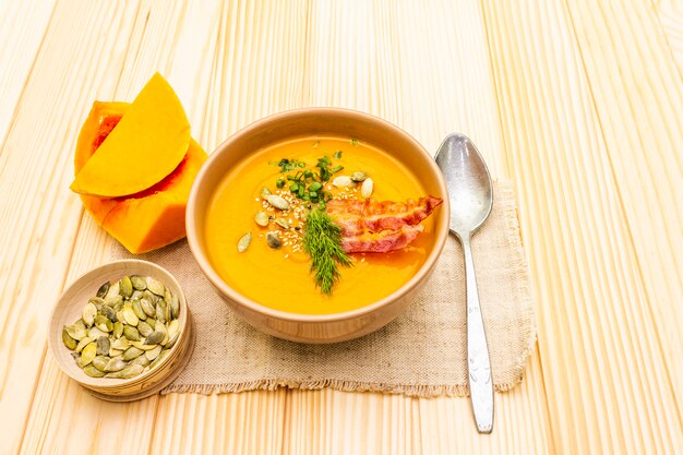 Potage chaud à la crème de potiron fait maison avec bacon fumé et graines