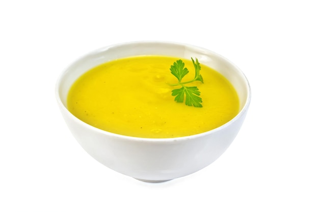 Potage-purée de citrouille avec du persil dans un bol blanc isolé sur fond blanc