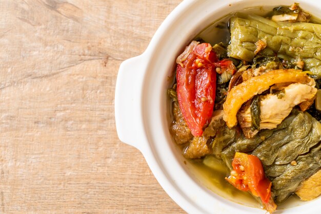 Potage vert de courge amère et moutarde confite au porc