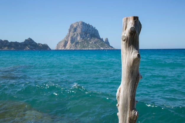 Poteau en bois à Hort Cove Beach avec Vedra Island Ibiza Espagne