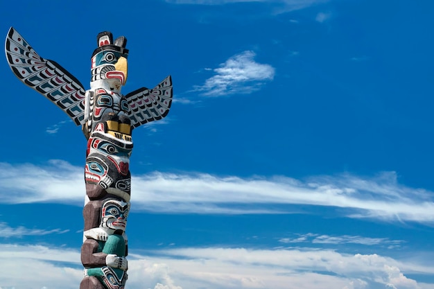 Poteau en bois de totem dans le fond bleu nuageux