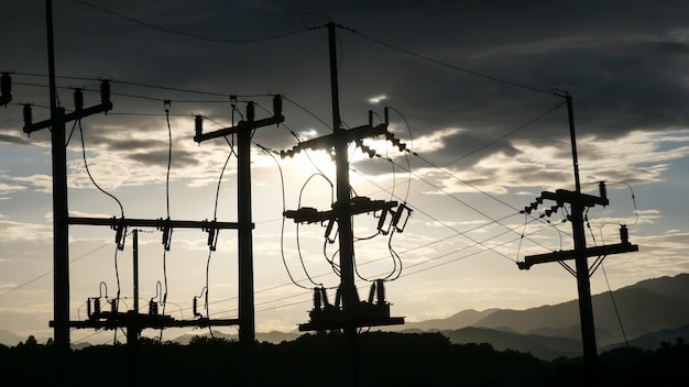 Les poteaux électriques contrastent avec le ciel au coucher du soleil le soir.