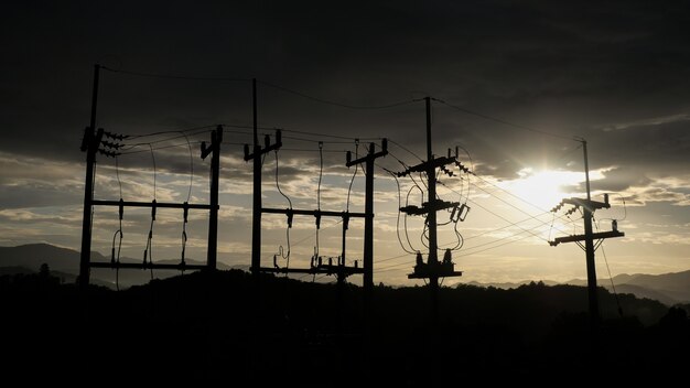 Les poteaux électriques contrastent avec le ciel au coucher du soleil le soir.