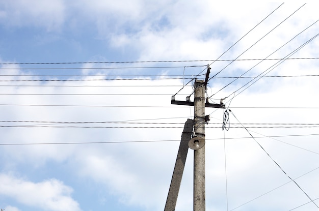 Poteaux électriques, fils à haute tension sur fond de ciel bleu