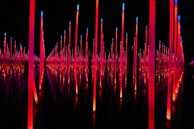 Photo poteaux lumineux led rouges abstraits dans la salle des miroirs à débordement