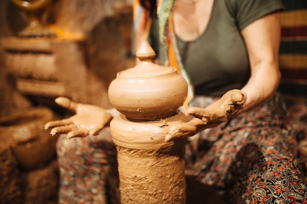 Potier de femme travaillant sur des mains en gros plan de tour