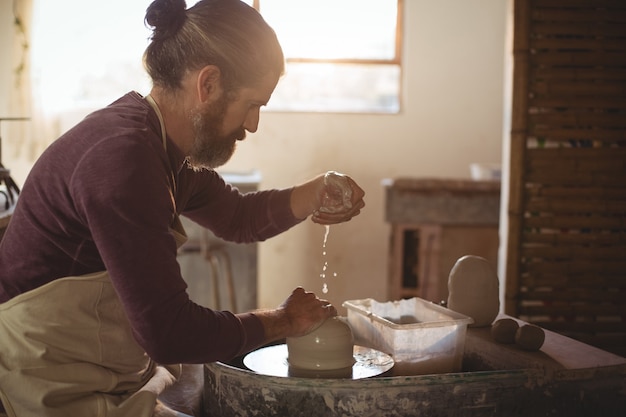 Potier mâle faisant un pot