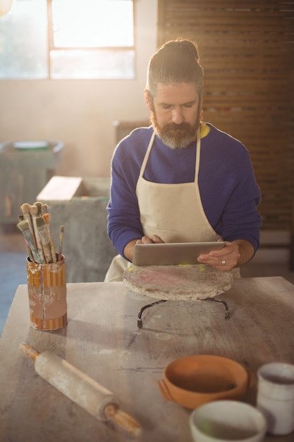 Potier masculin à l'aide de tablette numérique